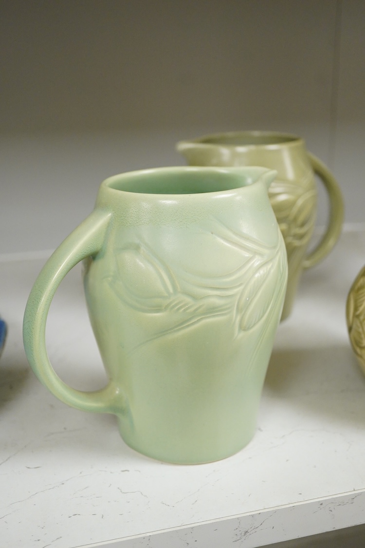 Three Susie Cooper green floral incised jugs, signed to the bases, tallest 16cm high